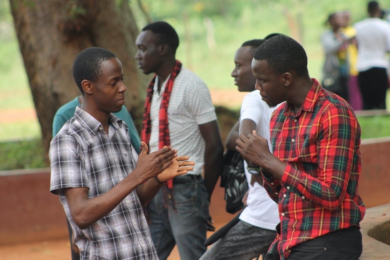 Young Kenyan men sitting in a guided mentorship circle in a community space